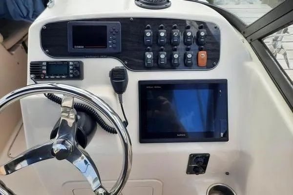 Slide: The Image of Control panel of a 2016 Grady-White Freedom 205 boat with steering wheel and electronics. - 17