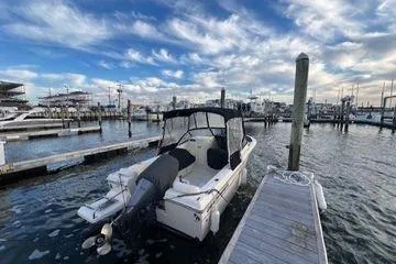 Slide: The Image of 2016 Grady-White Freedom 205 boat docked at a marina under a partly cloudy sky. - 4