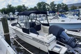 Slide: The Image of 2016 Grady-White Freedom 205 boat docked at a marina with canopy and outboard motor. - 6