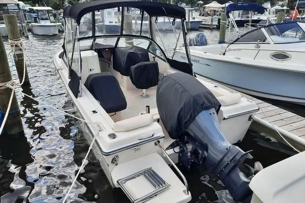 Slide: The Image of 2016 Grady-White Freedom 205 boat docked at marina, featuring covered seats and motor. - 7