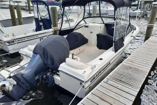 Slide: The Image of 2016 Grady-White Freedom 205 boat docked, featuring covered seating and outboard motor. - 8