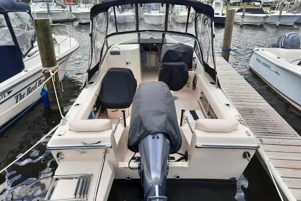 Slide: The Image of 2016 Grady-White Freedom 205 boat docked at marina, featuring covered seats and motor. - 9
