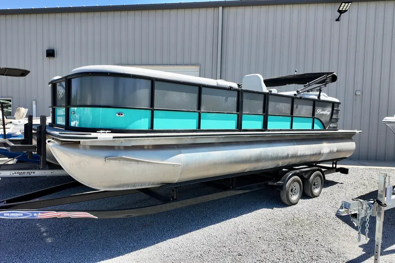 The Image of 2024 Bentley Pontoons 24 Legacy pontoon boat on trailer, parked outdoors. - 1
