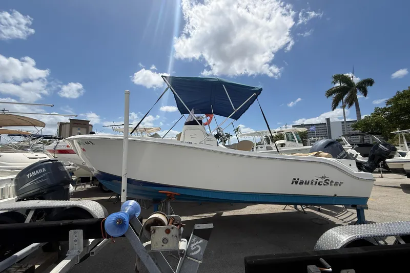 The Image of 2019 NauticStar 2102 Legacy boat on trailer under blue sky. - 0