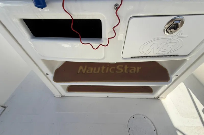 Slide: The Image of 2019 NauticStar 2102 Legacy boat dashboard with gauges and Simrad display. - 10
