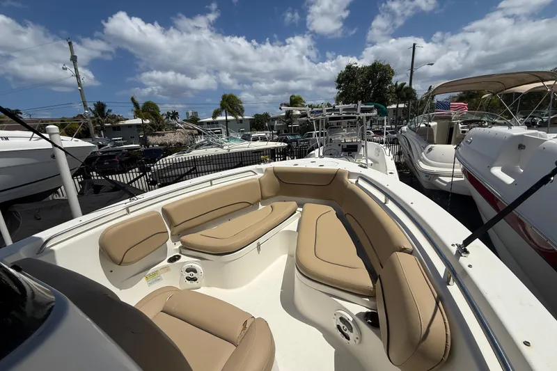 Slide: The Image of 2019 NauticStar 2102 Legacy boat with tan seating, docked among other boats. - 15