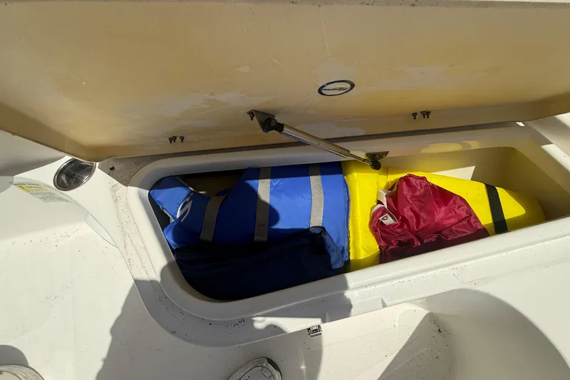 Slide: The Image of Storage compartment of 2019 NauticStar 2102 Legacy boat with life jackets and gear. - 18