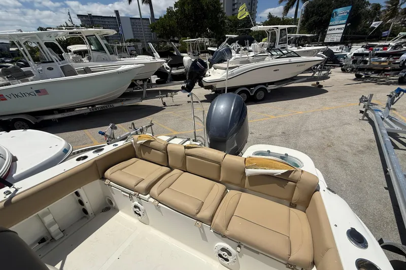 Slide: The Image of 2019 NauticStar 2102 Legacy boat with tan seating, visible engine, and minor upholstery damage. - 4