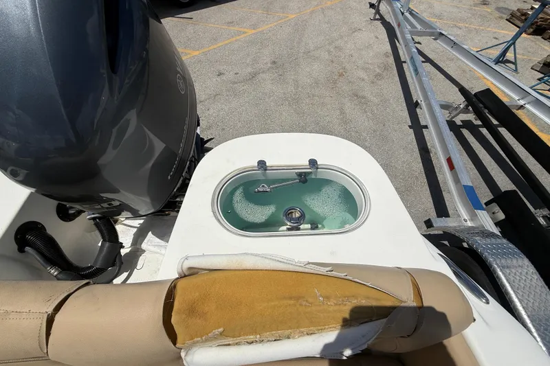 Slide: The Image of 2019 NauticStar 2102 Legacy boat interior with beige seating and fishing rod holders. - 7