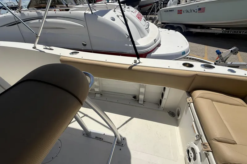 Slide: The Image of 2019 NauticStar 2102 Legacy boat interior with storage compartments and logo. - 8