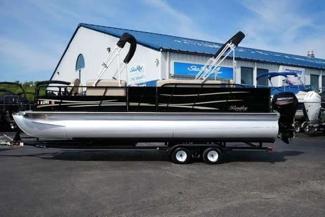 The Image of 2017 Bentley 244 pontoon boat on trailer, parked outside dealership. - 1
