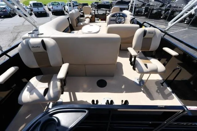Slide: The Image of 2017 Bentley 244 pontoon boat interior with beige seating and steering console. - 12