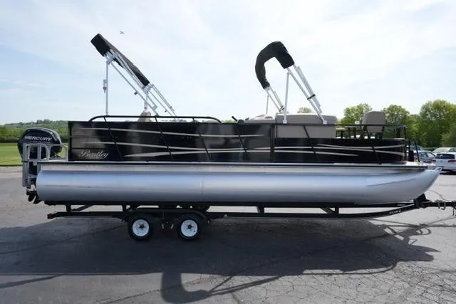 Slide: The Image of 2017 Bentley 244 pontoon boat on trailer, featuring sleek design and dual bimini tops. - 4
