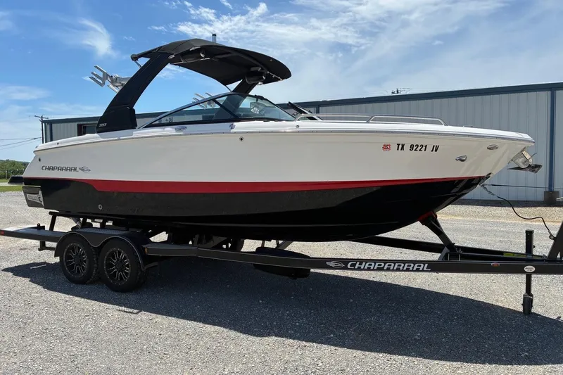 The Image of 2020 Chaparral 25 Surf boat on trailer, white and black with red stripe. - 1