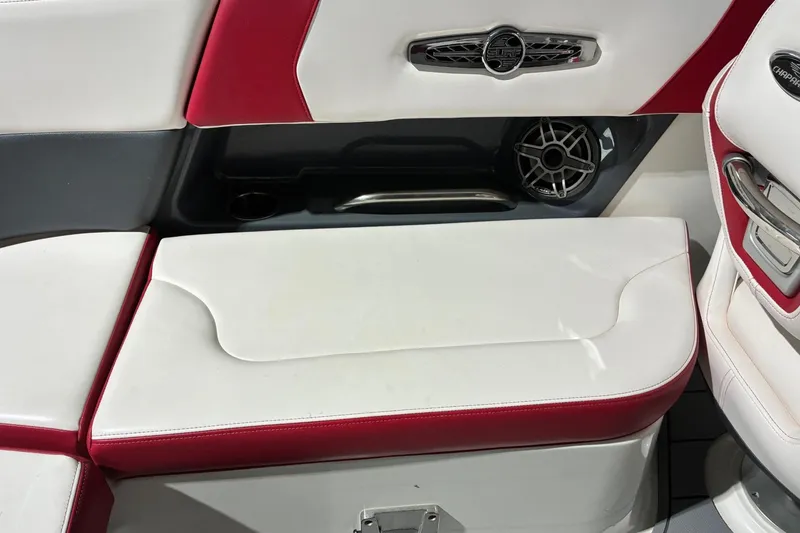 Slide: The Image of 2020 Chaparral 25 Surf boat interior with red and white seating and speaker detail. - 11