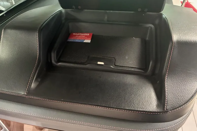 Slide: The Image of 2020 Chaparral 25 Surf boat interior with black leather seating and storage compartment. - 19