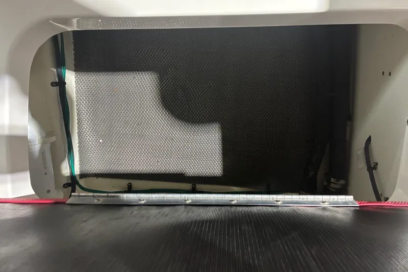Slide: The Image of Interior compartment of a 2020 Chaparral 25 Surf boat, featuring a mesh panel. - 26
