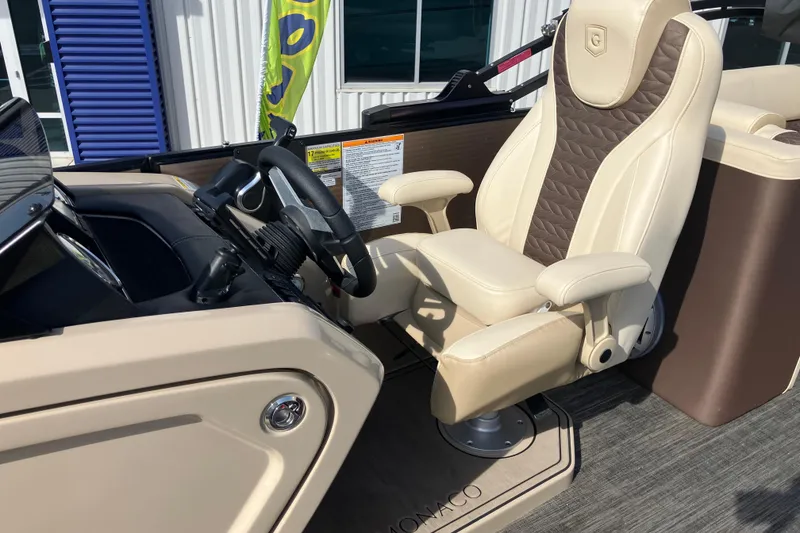 Slide: The Image of 2023 Godfrey Monaco 255 SB boat interior with luxurious captain's chair and steering console. - 18