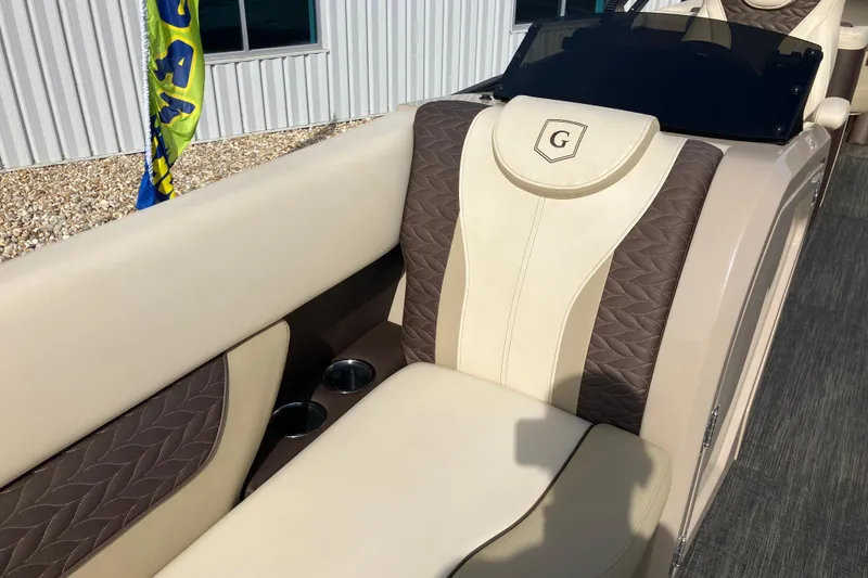 Slide: The Image of Luxurious seating on 2023 Godfrey Monaco 255 SB boat, featuring elegant brown and cream upholstery. - 22