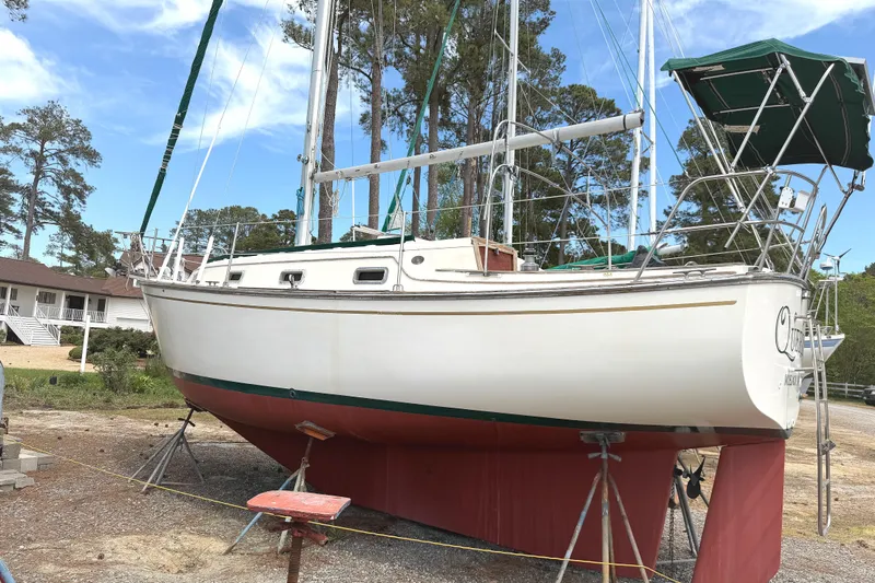 The Image of 1984 Island Packet sailboat on stands, surrounded by trees and a house in the background. - 1