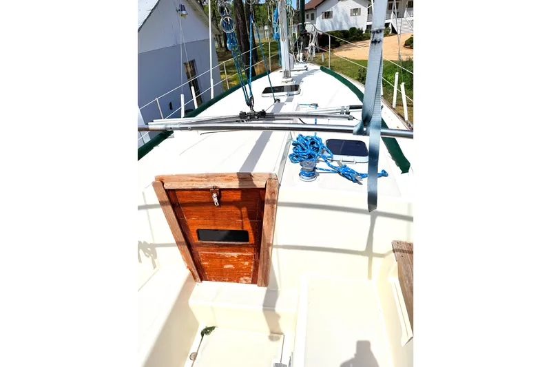 Slide: The Image of 1984 Island Packet sailboat deck with wooden hatch and blue ropes. - 16