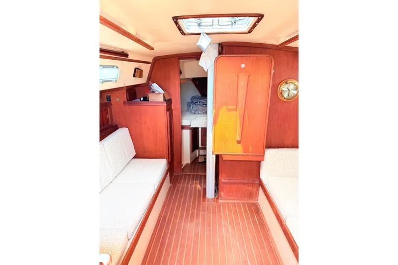 Slide: The Image of Interior of 1984 Island Packet sailboat with wooden finishes and cozy seating. - 19
