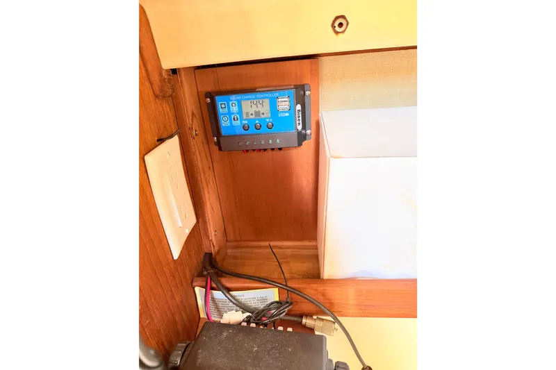 Slide: The Image of 1984 Island Packet boat interior with solar charge controller and electrical setup. - 26