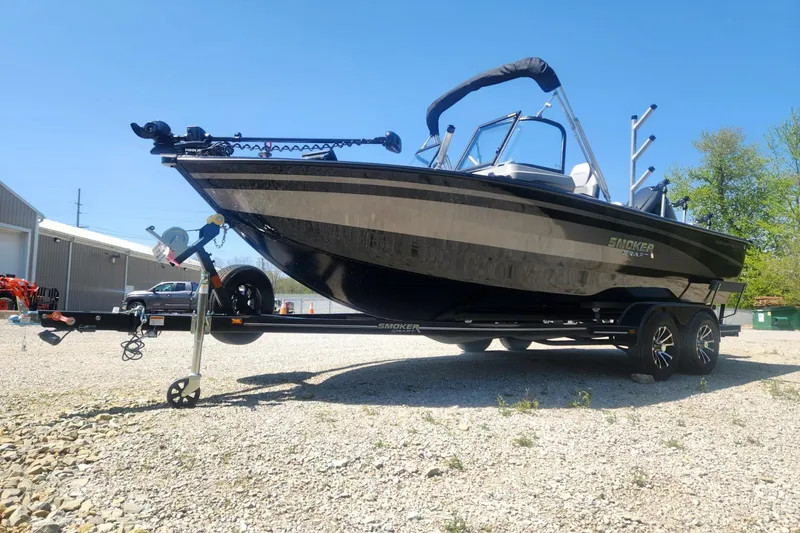 Slide: The Image of 2026 Smoker Craft Adventurer 210 GLS Sport boat on trailer, parked outdoors. - 13