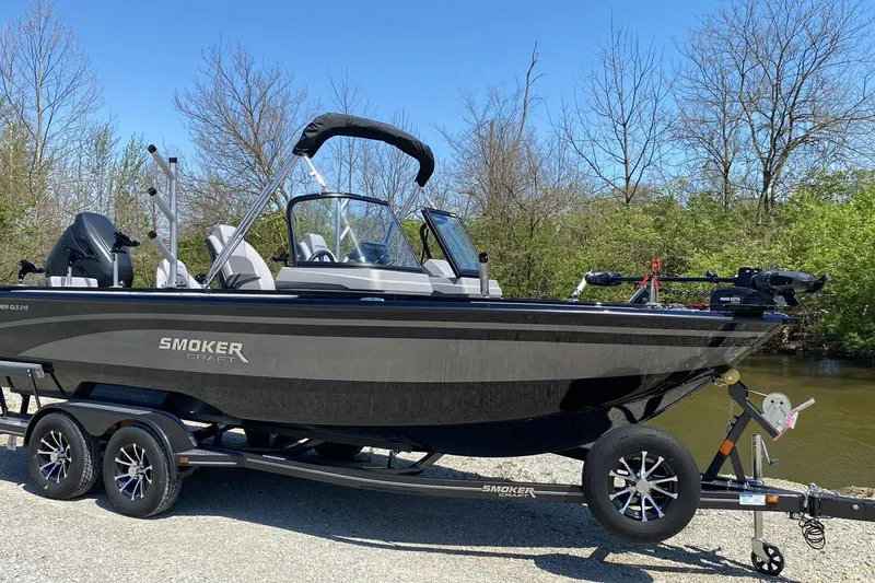 Slide: The Image of 2026 Smoker Craft Adventurer 210 GLS Sport boat on trailer by a riverbank. - 3