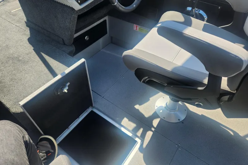 Slide: The Image of 2026 Smoker Craft Adventurer 210 GLS Sport interior with open storage compartment and swivel seat. - 32