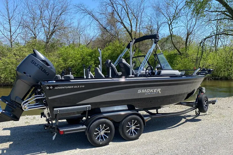 Slide: The Image of 2026 Smoker Craft Adventurer 210 GLS Sport boat on trailer by a river. - 4