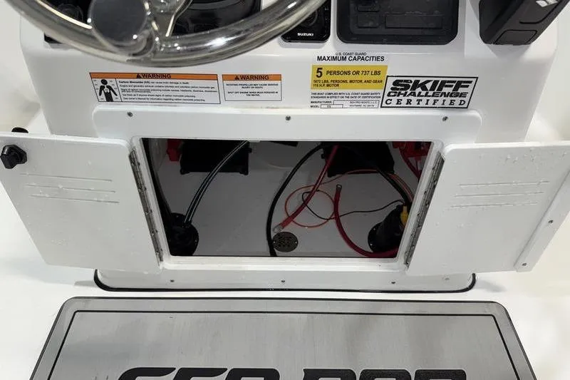 Slide: The Image of 2026 Sea Pro 172 Bay boat dashboard with open storage compartment and capacity warnings. - 11