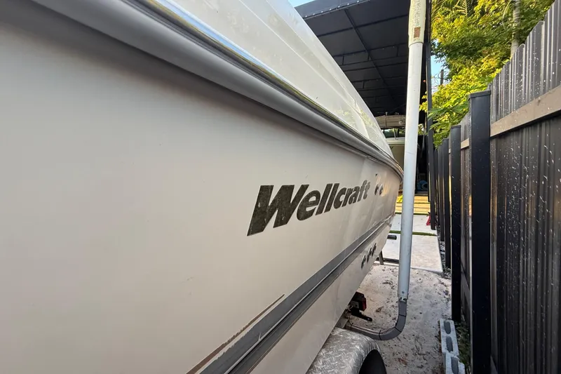 Slide: The Image of 2004 Wellcraft 32 CCF boat parked beside a black fence. - 10