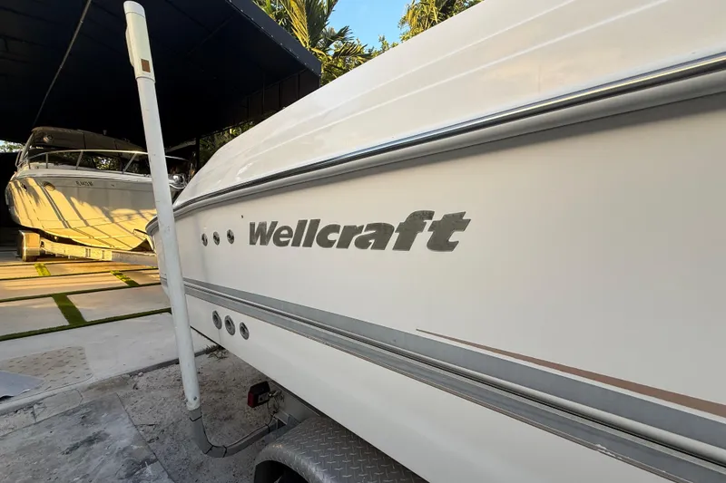 Slide: The Image of 2004 Wellcraft 32 CCF boat parked in a covered area, side view. - 11