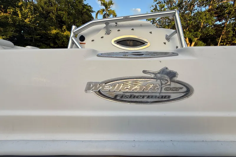 Slide: The Image of 2004 Wellcraft 32 CCF boat with logo, surrounded by trees and blue sky. - 12