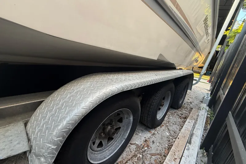 Slide: The Image of 2004 Wellcraft 32 CCF boat on a triple-axle trailer, parked outdoors. - 13