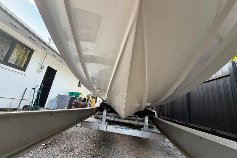 Slide: The Image of 2004 Wellcraft 32 CCF boat hull on trailer, parked beside a building. - 17