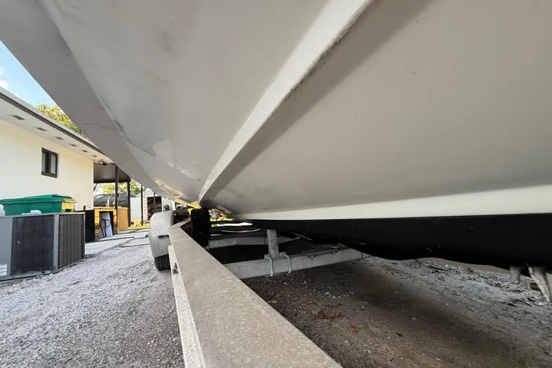 Slide: The Image of 2004 Wellcraft 32 CCF boat on trailer, side view, parked near a building. - 18