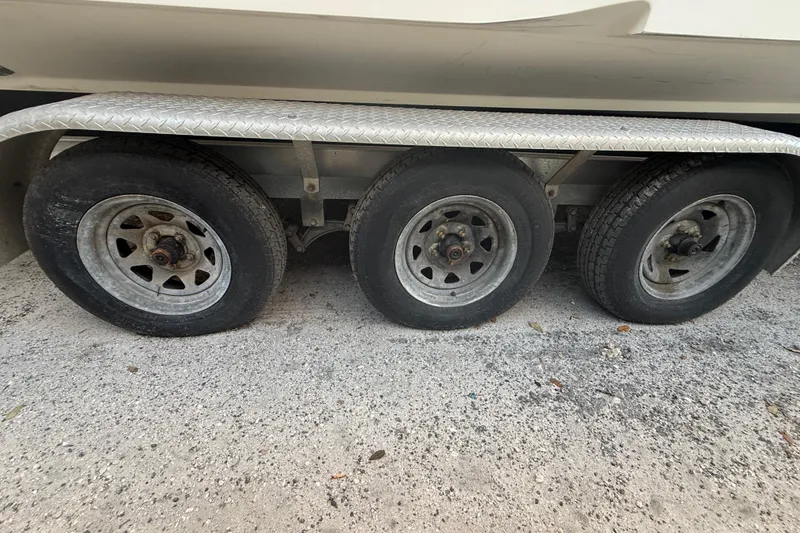 Slide: The Image of Triple-axle trailer for 2004 Wellcraft 32 CCF boat on gravel surface. - 20