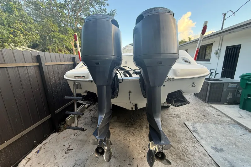 Slide: The Image of 2004 Wellcraft 32 CCF boat with dual outboard motors, parked outdoors. - 27