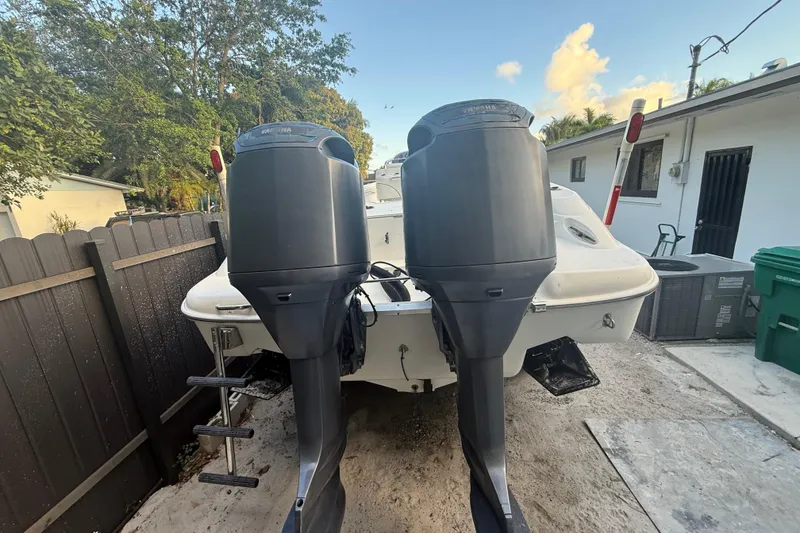 Slide: The Image of 2004 Wellcraft 32 CCF boat with dual outboard motors, parked in a residential driveway. - 28