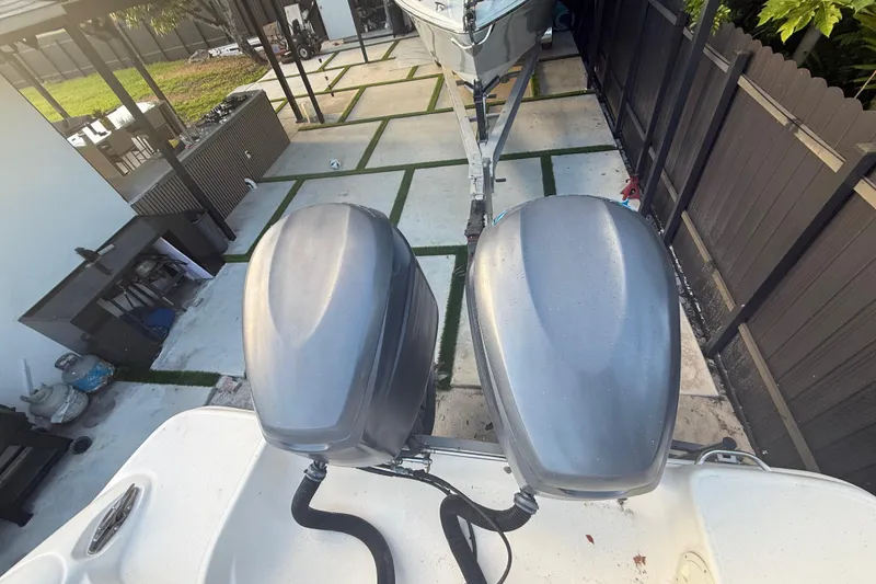 Slide: The Image of 2004 Wellcraft 32 CCF boat with dual outboard motors in a driveway. - 34