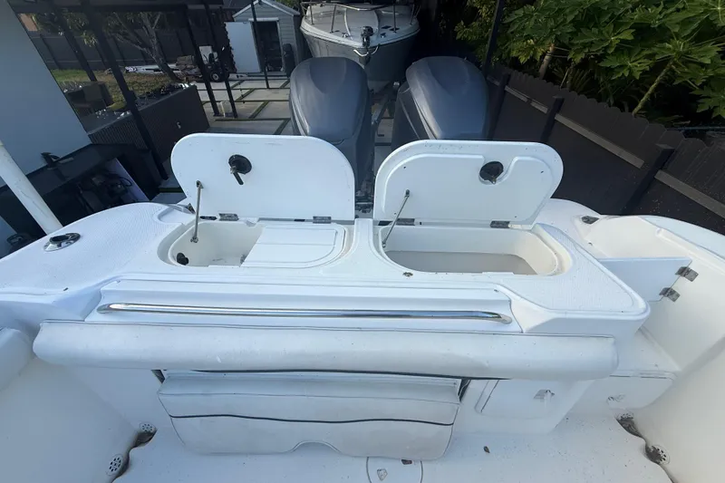 Slide: The Image of 2004 Wellcraft 32 CCF boat with open storage compartments and dual outboard motors. - 36
