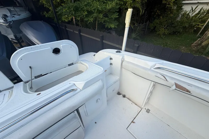 Slide: The Image of 2004 Wellcraft 32 CCF boat interior with open storage compartment and visible wear. - 38