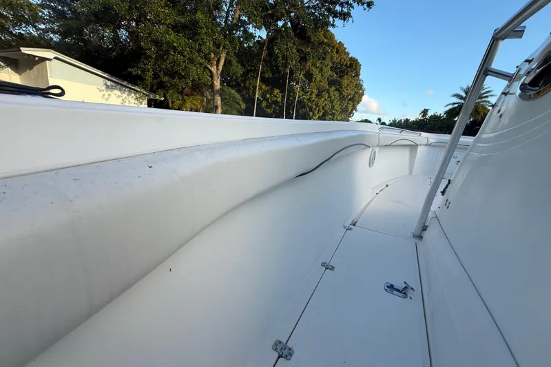 Slide: The Image of 2004 Wellcraft 32 CCF boat deck with white interior and railing, surrounded by trees. - 45