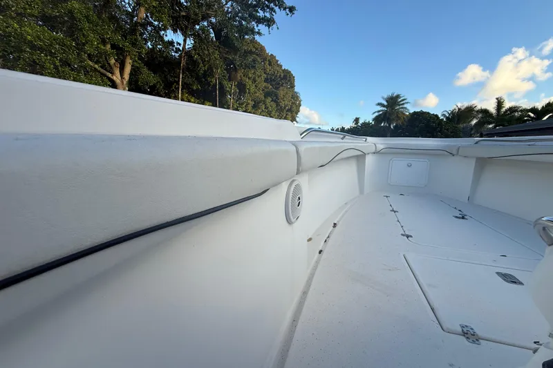 Slide: The Image of 2004 Wellcraft 32 CCF boat interior with white deck and seating, surrounded by trees. - 46