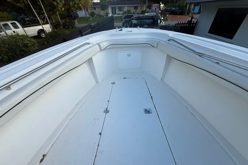 Slide: The Image of 2004 Wellcraft 32 CCF boat interior, showcasing spacious white deck and storage compartment. - 56