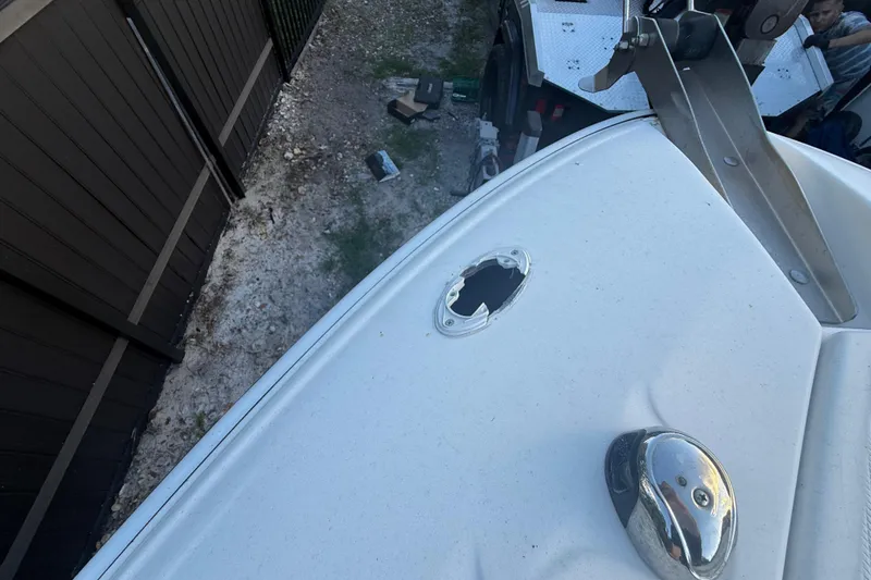 Slide: The Image of 2004 Wellcraft 32 CCF boat with visible damage on the deck near a fence. - 60