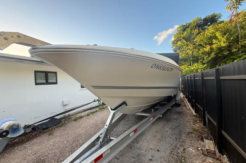 Slide: The Image of 2004 Wellcraft 32 CCF boat on trailer, parked beside a house and fence. - 8