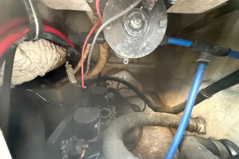 Slide: The Image of Engine compartment of a 2004 Wellcraft 32 CCF boat, showing wiring and hoses. - 90